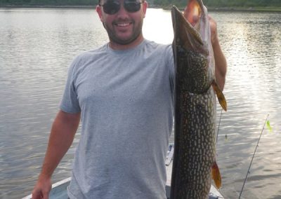 guy holding pike vertically in boat